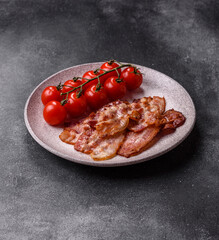 Cooked crispy fried pork bacon strips for a hearty breakfast. Fried bacon strips
