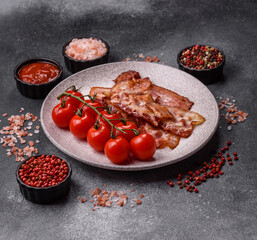 Cooked crispy fried pork bacon strips for a hearty breakfast. Fried bacon strips