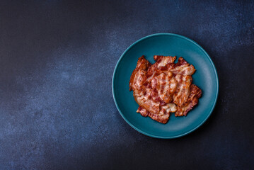 Cooked crispy fried pork bacon strips for a hearty breakfast. Fried bacon strips