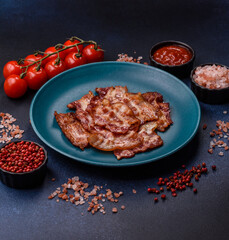 Cooked crispy fried pork bacon strips for a hearty breakfast. Fried bacon strips