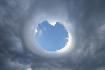 Hole in dramatic storm clouds with swirling grey sky, majestic cloudscape, natural turbulence, epic thunderstorm, mysterious light breaking through, fluffy portal, atmospheric background, fantasy sky
