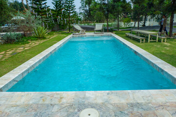 Empty swimming pool with sunbed and white umbrella in resort hotel for vacation leisure and white sand,resort neary sea and beach in summer.