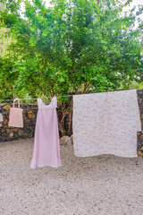 Different clothes drying on laundry line against garden background,clothes hanging laundry on washing line for drying towels drying on the clothesline.
