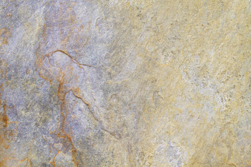 Natural stone background texture with yellow, beige and purple tones