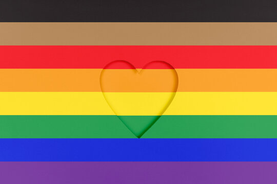 LGBTQ pride flag background. Rainbow Printed cardboard with die-cut heart shape