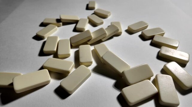 Falling dominoes in slow motion. Close-up of the domino effect. Chain reaction concept.