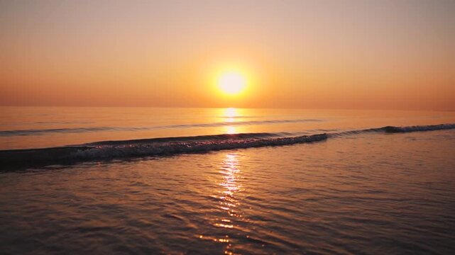 Beautiful sunset at Mandvi Beach in Kutch, Gujarat, India. Sunset beach background. Small waves crashing on shore during low tide in evening. Nature landscape. Summer vacation and holidays background.
