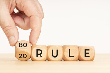Pareto principle concept. 80 and 20 rule. Hand flipping a wooden block with text. Copy space. White background