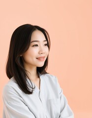 Portrait of a young asian woman with dark hair and a light blue shirt looking up and smiling