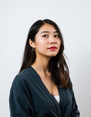 Portrait of a young asian woman with long dark hair and red lipstick against white wall