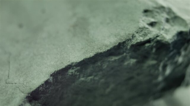 Close-up of a rock video loop background, rotating and showing its rough surface and crumbly texture. Hazardous material sample revealing its dangerous nature