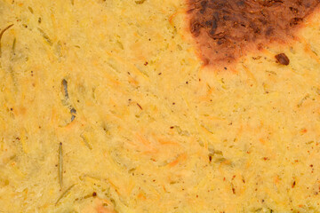A close-up, top-down view of a baked potato scarpaccia, showcasing the rustic golden-brown texture of the grated potatoes and crust