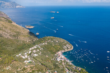 Aerial view of Marina del Cantone in Massa Lubrense on the Amalfi Coast during a sunny summer day. Clear blue sea, beaches, and Mediterranean coastline create a perfect Italian holiday destination.