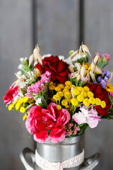 Beautiful bouquet of summer flowers in vintage can. Rustic style.