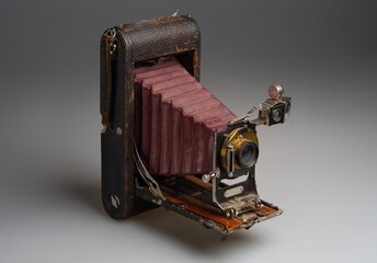 Old fashioned, antique photo camera close up on gray background