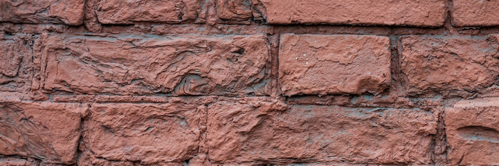 Old red brick wall. The texture of weathered grungy brickwork. Wide panoramic background with masonry.