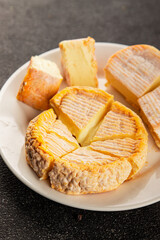 Cheese plate camembert, brie, munster french cheese tasty snack fresh delicious gourmet food background on the table rustic food top view copy space