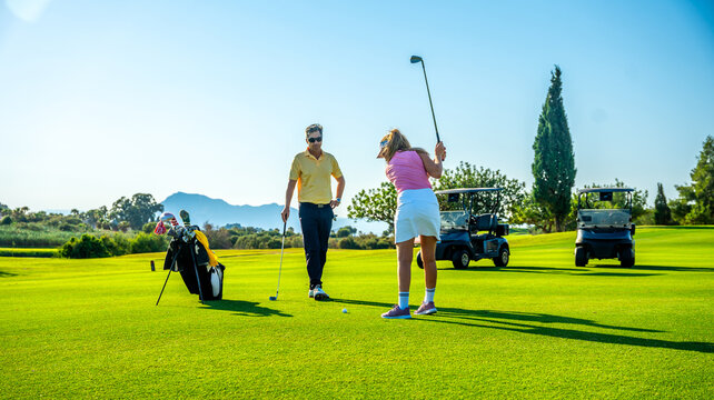 Golfers playing golf on sunny day at golf course