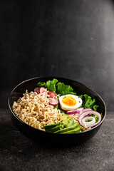 Vegetarian noodle bowl avocado, noodles, egg, vegetables tasty snack fresh delicious gourmet food background on the table rustic food top view copy space keto and paleo diet vegetarian food