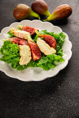 Salad figs, soft cheese, green leaf lettuce tasty snack fresh delicious gourmet food background on the table rustic food top view copy space keto and paleo diet vegetarian food