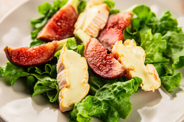 Salad figs, soft cheese, green leaf lettuce tasty snack fresh delicious gourmet food background on the table rustic food top view copy space keto and paleo diet vegetarian food