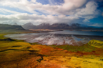 Aerial view of vivid colorful river and mountain landscape in Iceland shore during spring time.