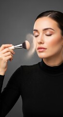 Fototapeta premium Young caucasian female applying makeup with brush on face