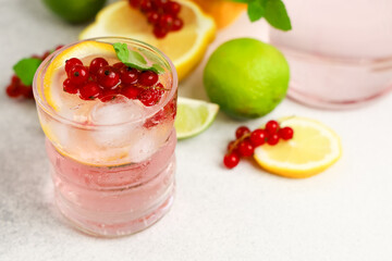 Refreshing pink drink with citrus fruits and berries garnished on a bright table
