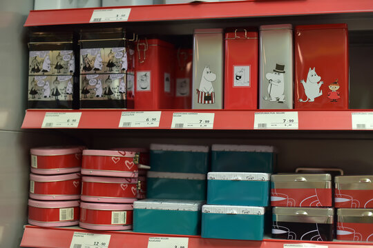 shelves in a store with metal cans and boxes with images of characters from the Moomin series.  