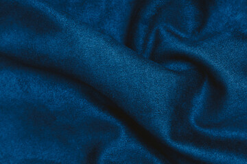 Fototapeta premium Soft textured blue fabric draped elegantly on a flat surface in indoor lighting