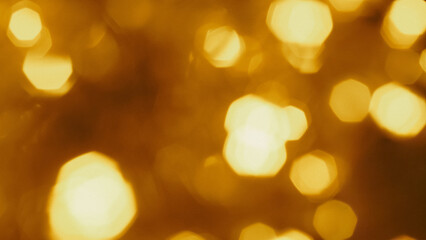 Blurred golden Christmas garland creating soft glowing festive bokeh background.