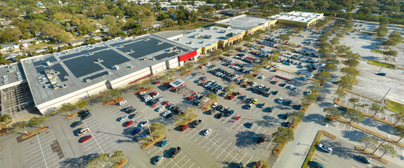 Large parking lot with many parked cars. Big carpark at supercenter shopping mall with lines and...