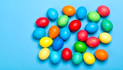 Obraz premium Vibrant colored eggs arranged in a whimsical pattern on a bright blue background.