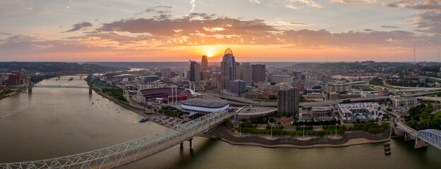 Sunset urban landscape of downtown district of Cincinnati city in Ohio, USA. Skyline with bridge traffic and brightly illuminated high skyscraper buildings in modern American megapolis