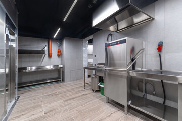 Clean and spacious commercial kitchen featuring stainless steel countertops, professional-grade washing stations, and efficient storage solutions, ideal for food service operations