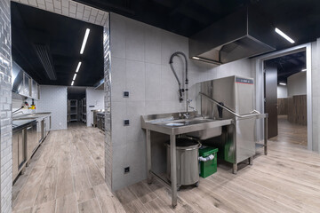 Well-equipped commercial kitchen showcasing sleek stainless steel surfaces, ample storage, and organized workspaces suitable for food preparation and cooking