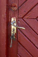 Old red wooden door with a rusty lock and bolt