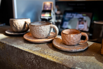 A set of designer ceramics in a cafe. Rustic clay dishes. Beautiful cups of different sizes