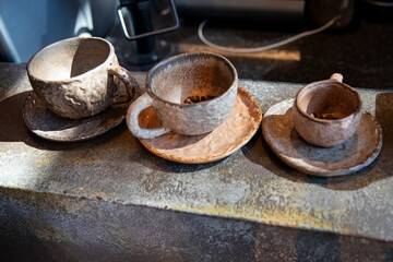 Handmade ceramic cups on a shelf. Small, medium and large cup