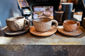Natural clay tableware for coffee and tea. Beautiful cups for a restaurant, cups of different sizes