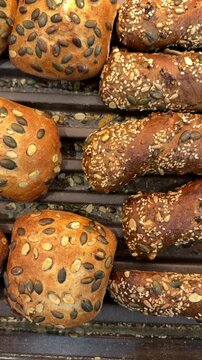 Assortment of seeded rolls, bagels and pretzels in bakery display