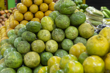 Green and yellow passion fruits piled up at a market stall.