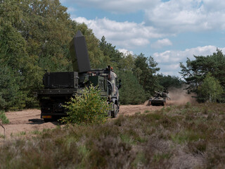 Fototapeta premium Military radar truck leading convoy with other vehicles during field exercise