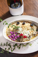 Delicious gourmet meal of potato gratin with edible flowers and olives