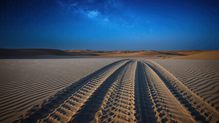 Naklejka premium Traces of tire tracks across a serene desert landscape at twilight