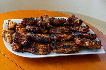 A delicious plate of assorted barbecue meats, including pork, chicken, and beef, freshly grilled and served hot for a hearty meal.