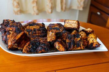 A delicious plate of assorted barbecue meats, including pork, chicken, and beef, freshly grilled and served hot for a hearty meal.
