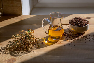 Flaxseed oil and flax seeds. Proper nutrition. Flax oil in glass carafe and flax seeds in bowls with dry flax fruits with ripe seeds. Healthy omega 3 nutrient for vegetarian recipe. Focus Stacking