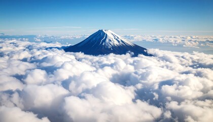 Majestic peak emerges amidst a sea of ethereal clouds under a clear sky