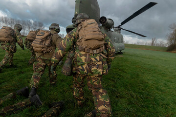 Soldiers moving toward helicopter for boarding during tactical transport operations